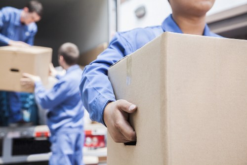 Moving team handling boxes safely with protective equipment